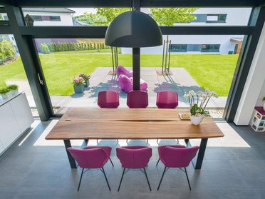 Gemütliches Architektenhaus mit stilvollem Essbereich Moderne Esszimmeransicht mit Holzstuhl und Gartenblick
