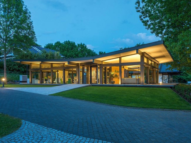 Ein elegantes Gebäude mit großzügigen Glasflächen und eingerichteten Gärten