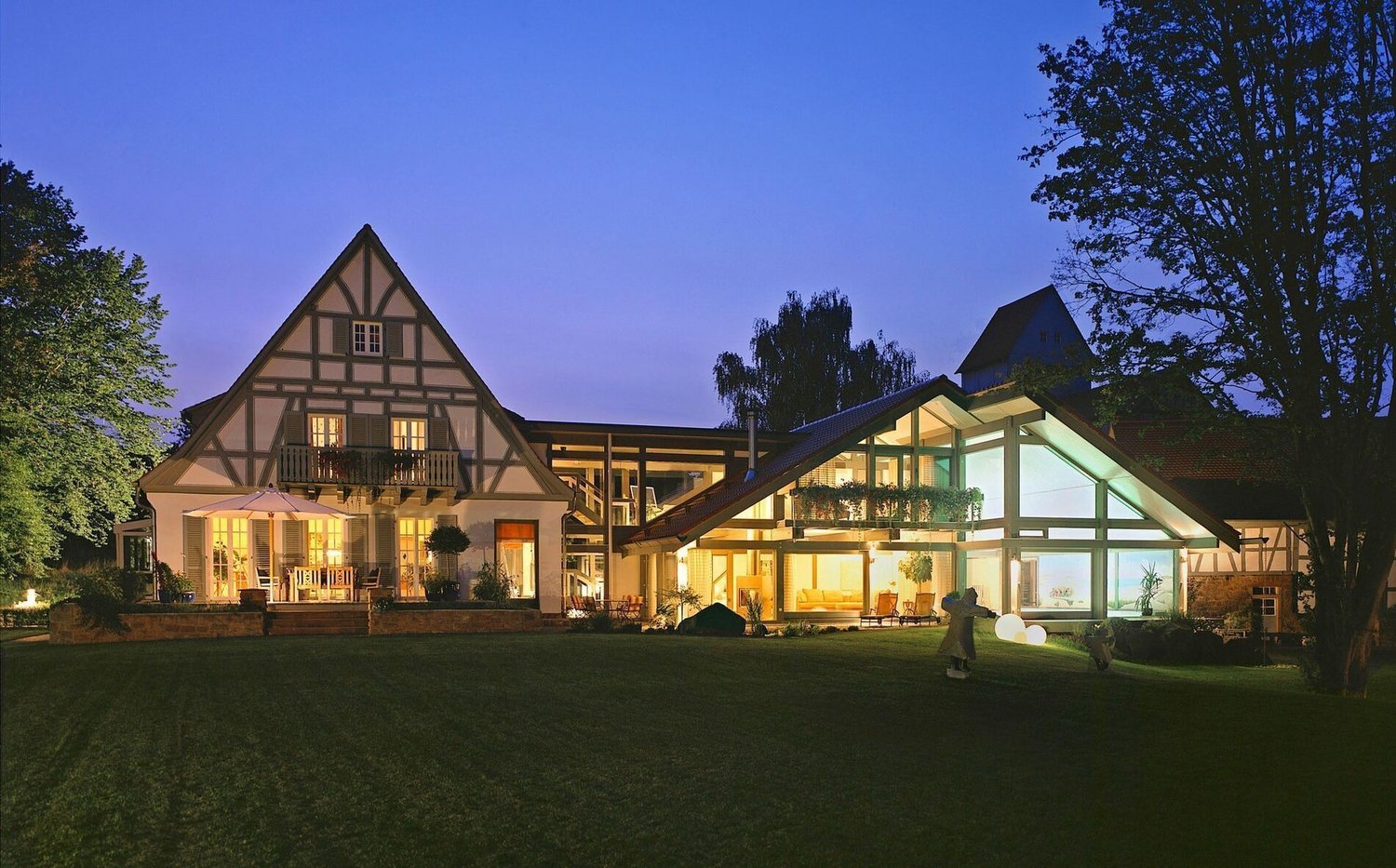 Moderne Hausanbauten mit individuellem Design Abendansicht eines Hauses mit unterschiedlichen Anbauten und Garten