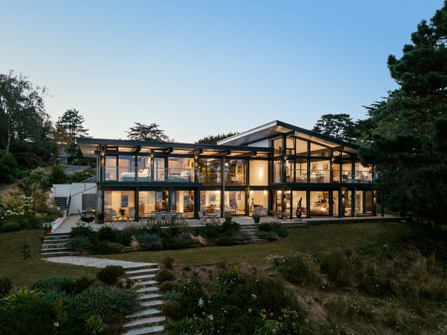 Moderne Architektur mit großen Fenstern und Gartenlandschaft