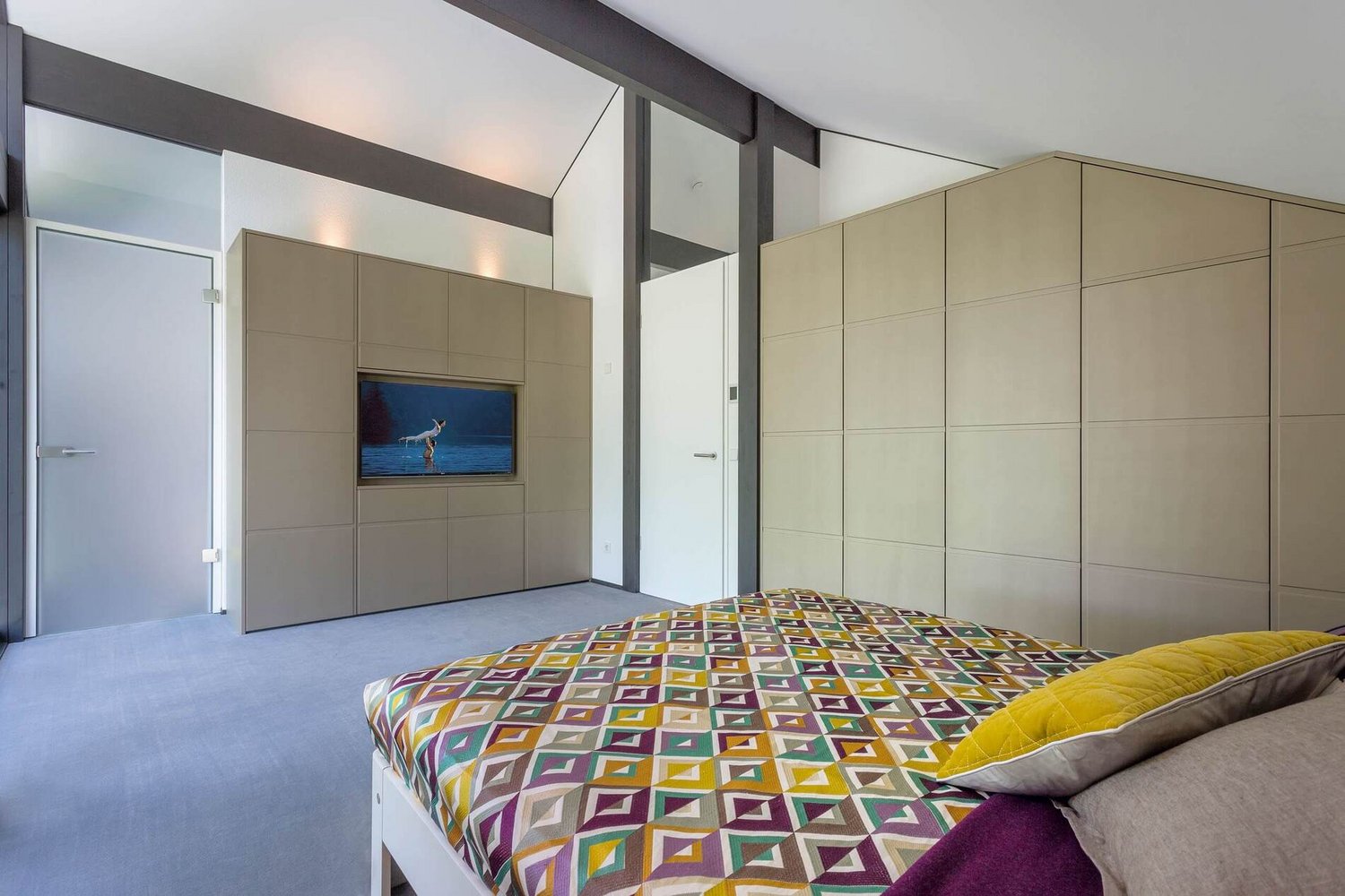 HUF house modum 810 22 Helles Schlafzimmer mit TV und geometrischem Bettüberwurf