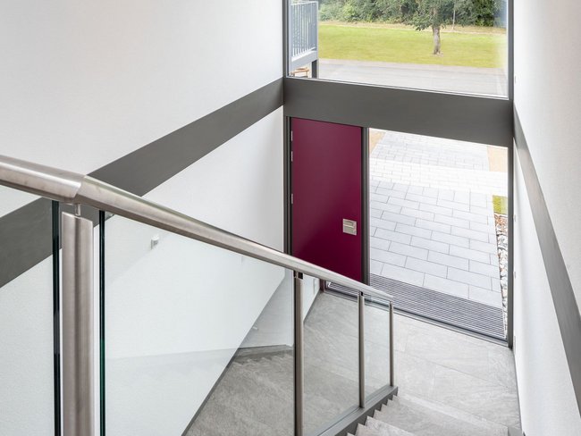 Treppenhaus eines modernen Fertighauses mit Glasfenster und Eingang