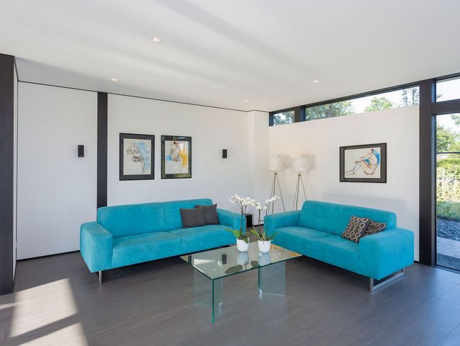 Helles Wohnzimmer mit blauen Sofas und moderner Einrichtung
