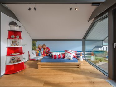 Modernes Zimmer mit blauem Bett und maritimen Dekoren.