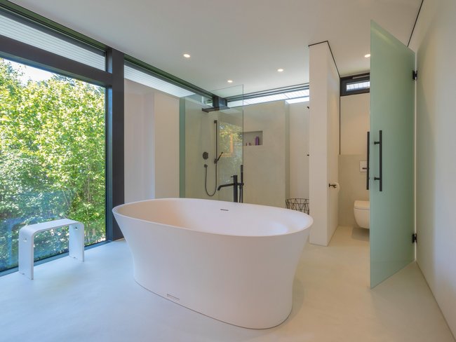 Helles Badezimmer mit freistehender Badewanne und Glasduschbereich