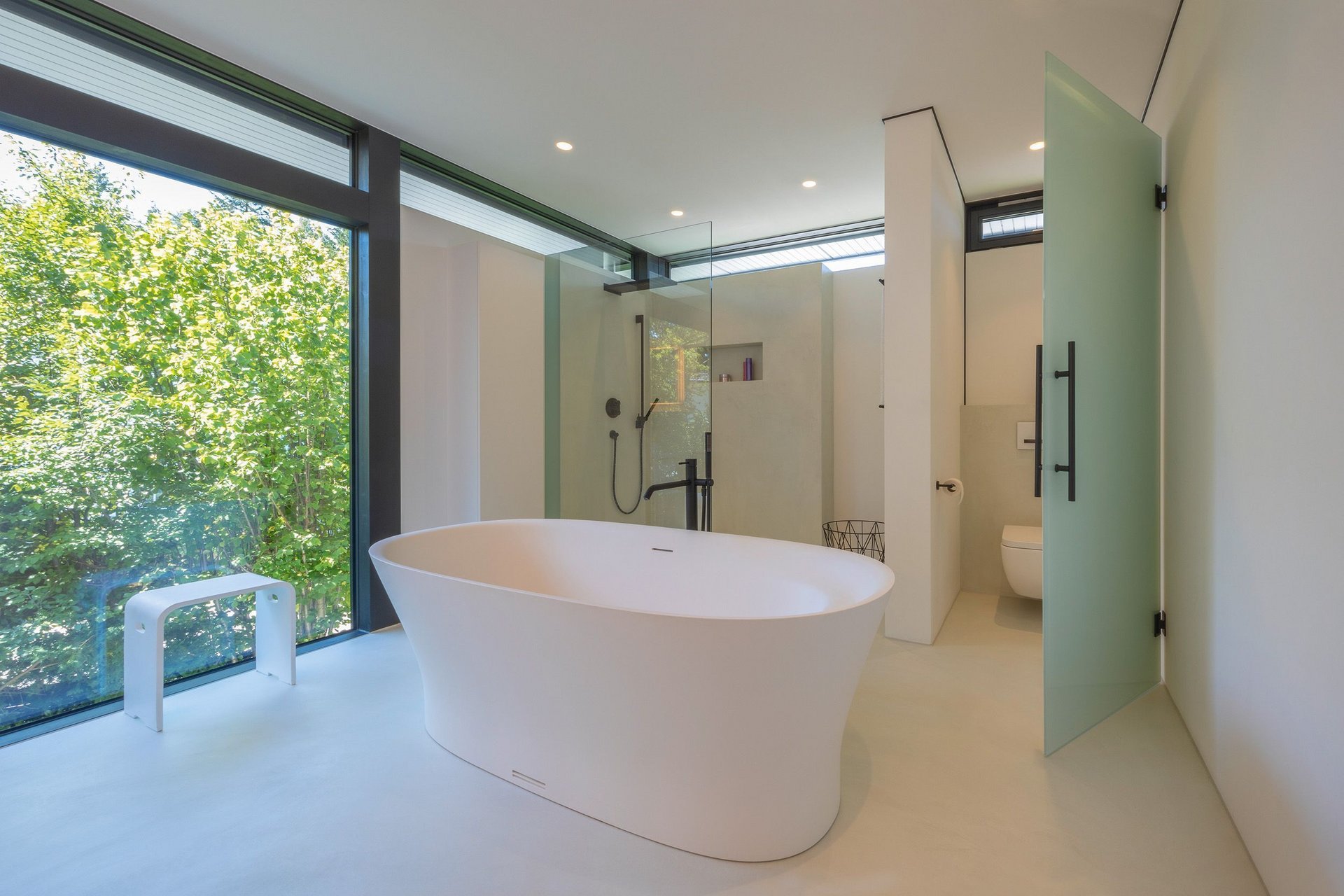 Helles Badezimmer mit freistehender Badewanne und Glasduschbereich