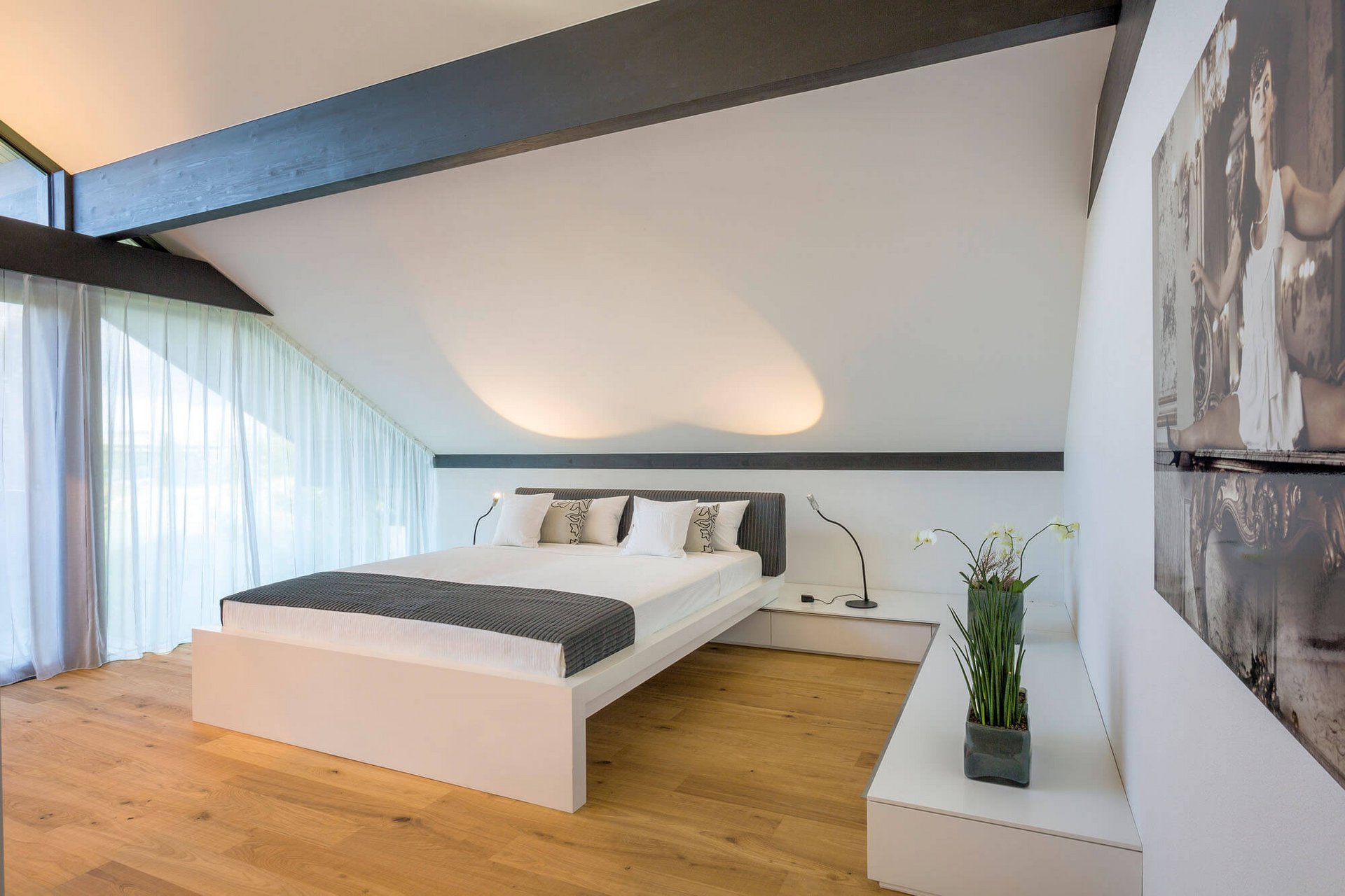Helles Schlafzimmer mit großer Fensterfront und minimalistischer Einrichtung