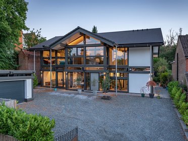 Moderner Bau: HUF Stadthaus mit großflächigen Fenstern Zeitgenössisches Stadthaus mit großzügigen Glasflächen und umliegender Vegetation