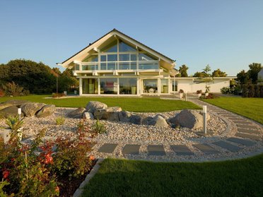 Modernes Fachwerkhaus mit großzügiger Glasfront und Gartenlandschaft
