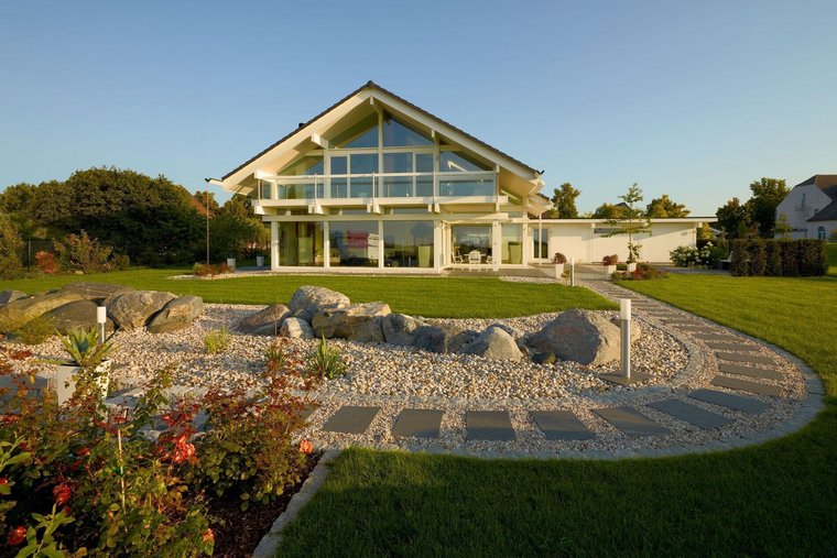 Modernes Fachwerkhaus mit großzügiger Glasfront und Gartenlandschaft