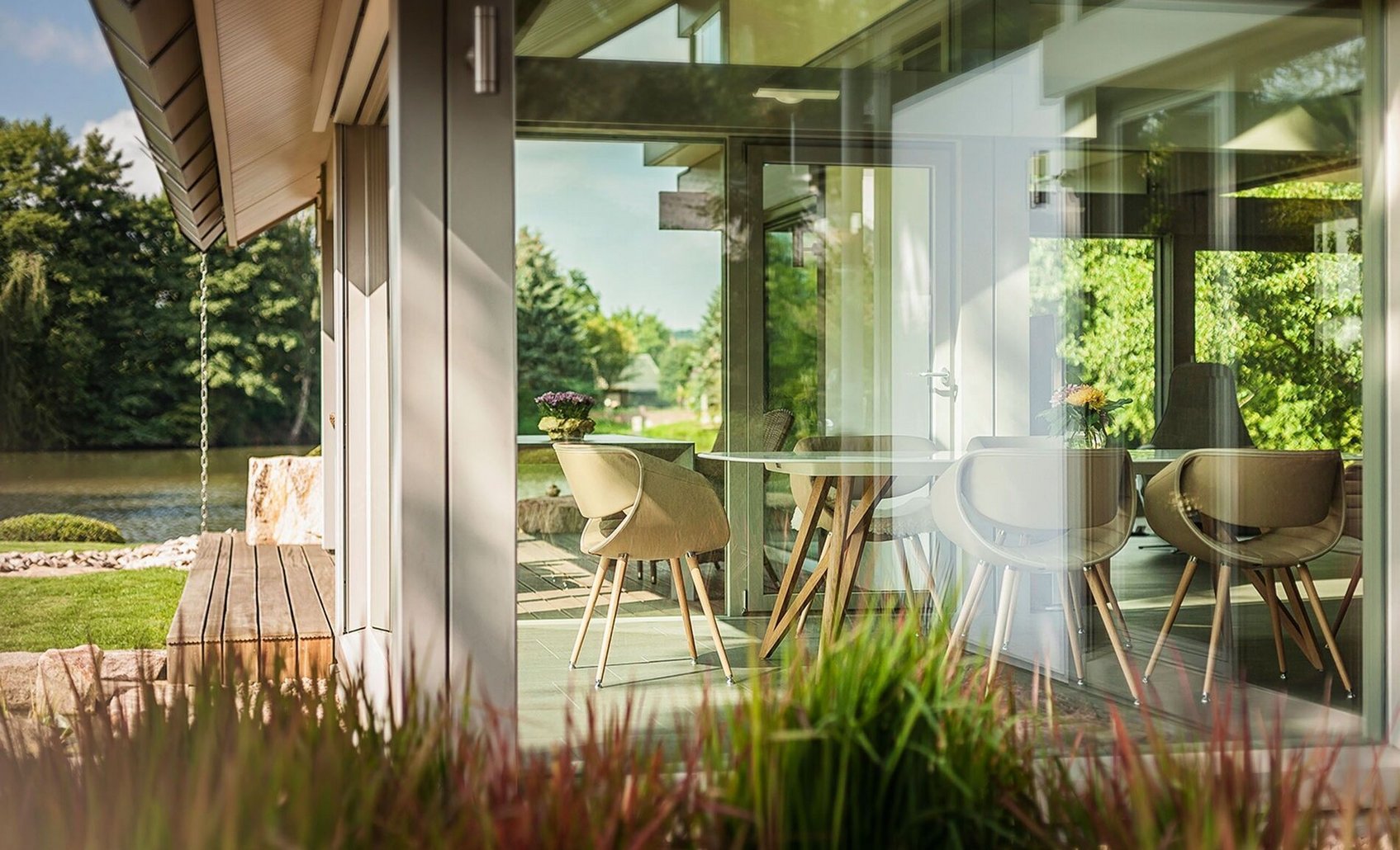 Moderne Architektur mit Naturblick Helles Wohnzimmer mit großen Fenstern und Blick ins Grüne