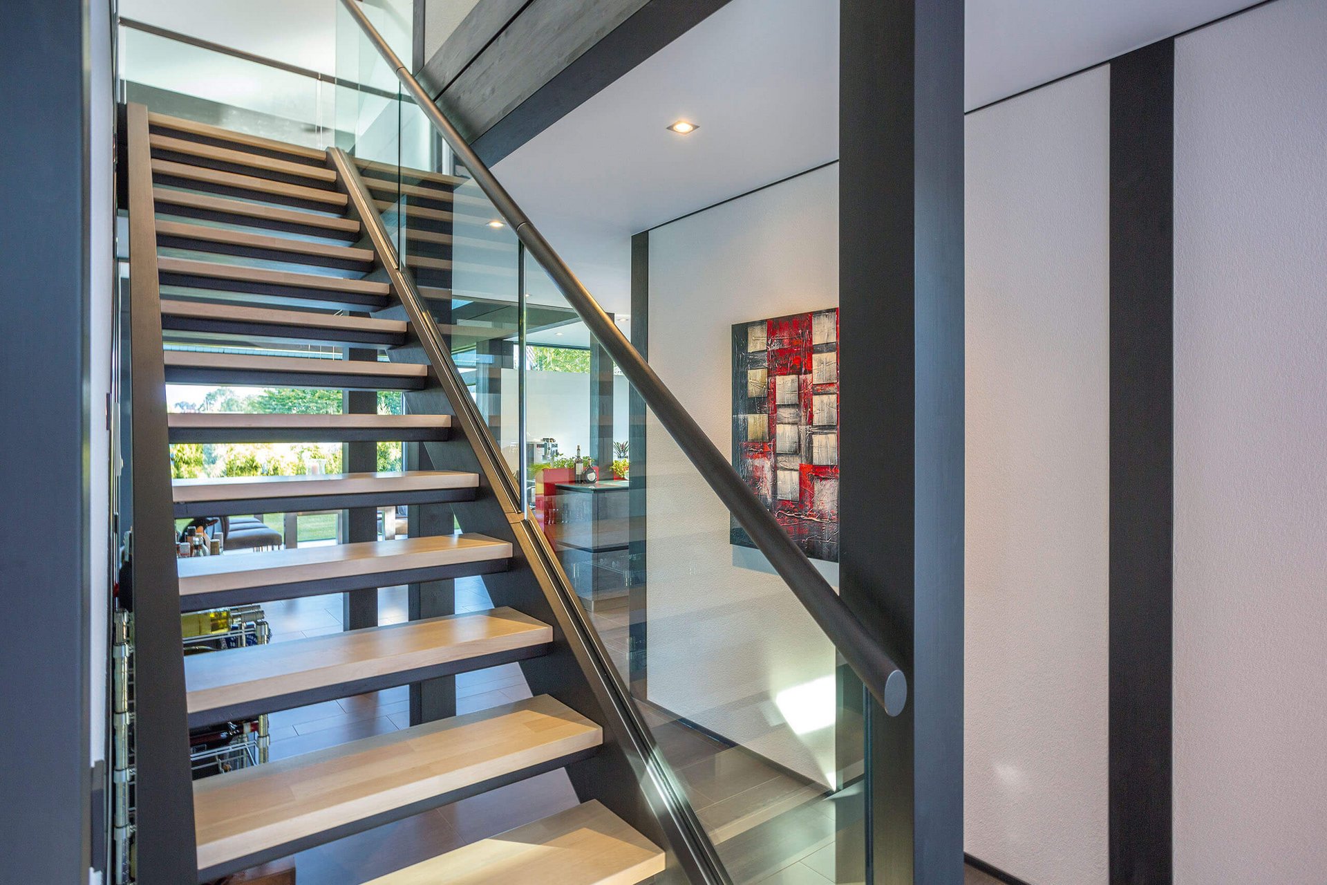 Moderne Treppe in einem zeitgenössischen Wohnraum Innenansicht einer modernen Treppe mit Glasgeländer und Holzstufen