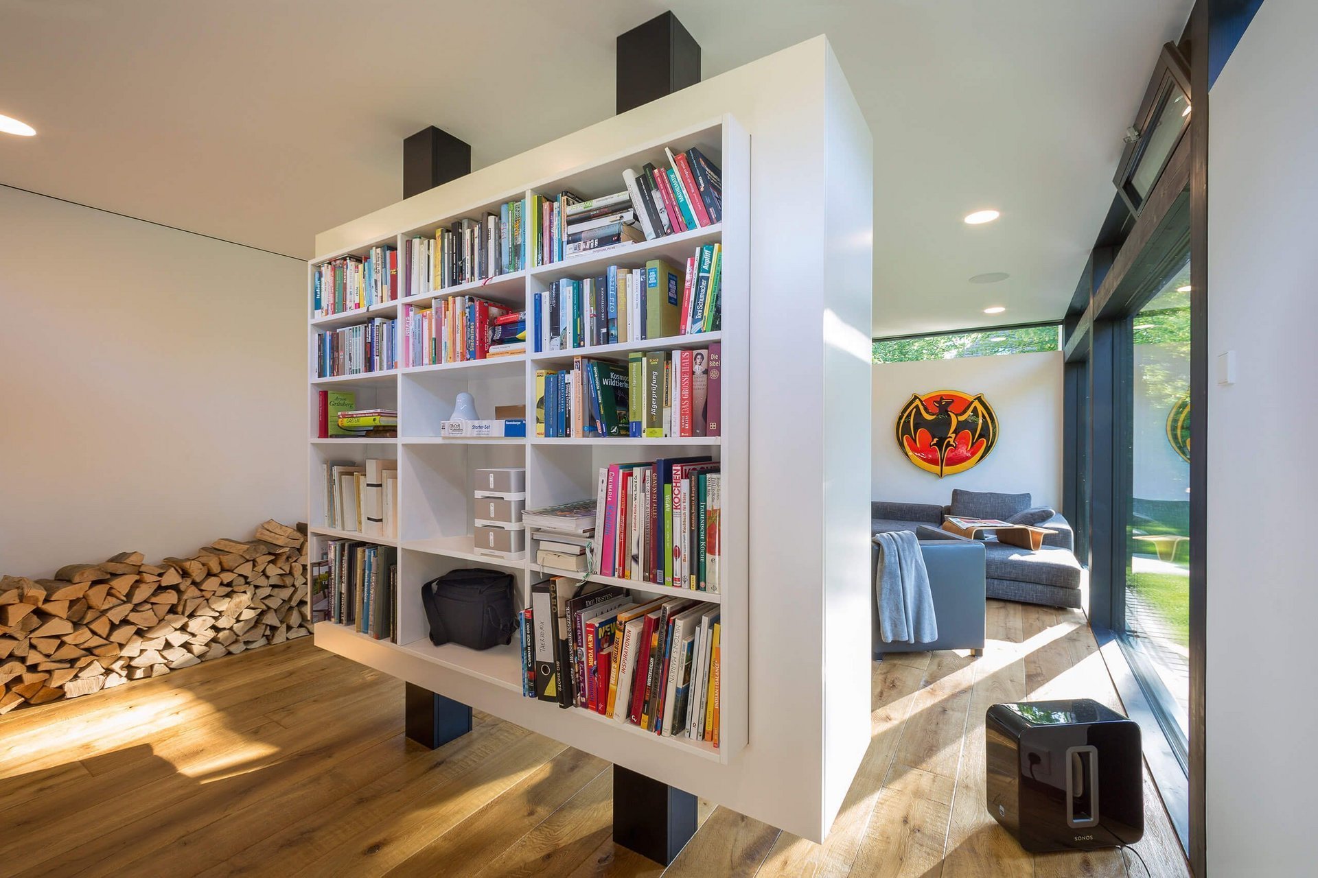 Interior eines modernen Wohnraums mit Bücherregal und Holzstapel