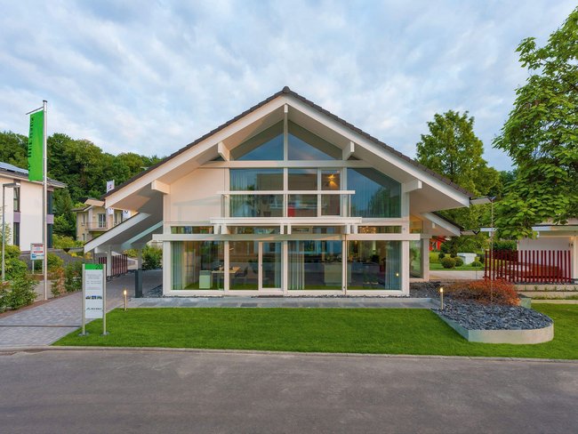 HUF Musterhaus Frankfurt weiss 37 Futuristisches Gebäude mit Glasfassade und gepflegtem Außenbereich