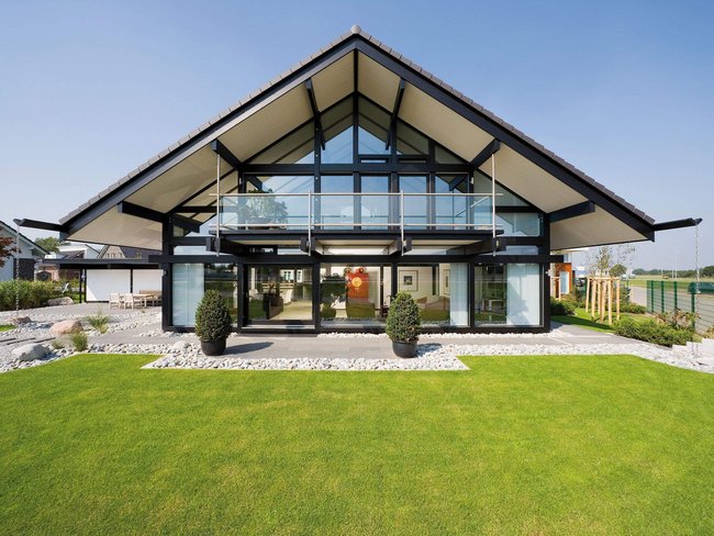 Stylisches Haus mit Garten, großen Fenstern und modernem Design