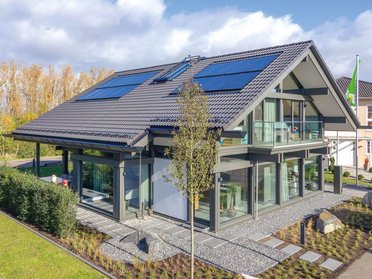 Einfamilienhaus mit großen Fenstern und schönem Garten