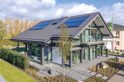 Einfamilienhaus mit großen Fenstern und schönem Garten