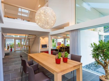 Helles Esszimmer mit großem Tisch und modernen Möbeln