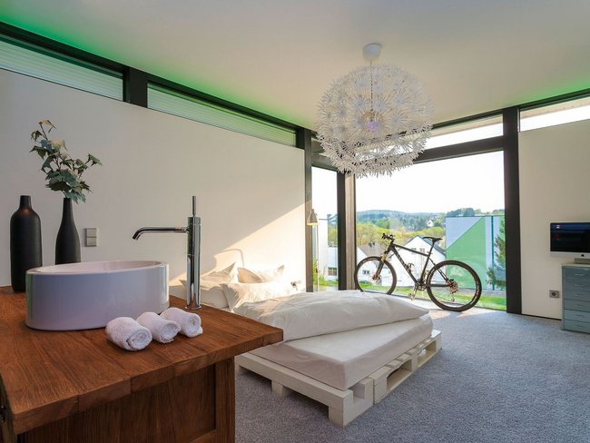 HUF modum Flachdach ebenholz 14 Helles modernes Zimmer mit Bett, Fahrrad und stilvollem Design
