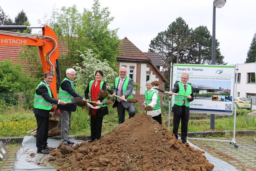 Spatenstich für Hospiz St. Thomas Gruppenfoto beim Spatenstich mit Schaufel und Baukran