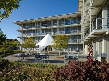 Modernes Bürogebäude mit grüner Umgebung Bürogebäude mit ungewöhnlicher Architektur und Gestaltungselementen im Freien