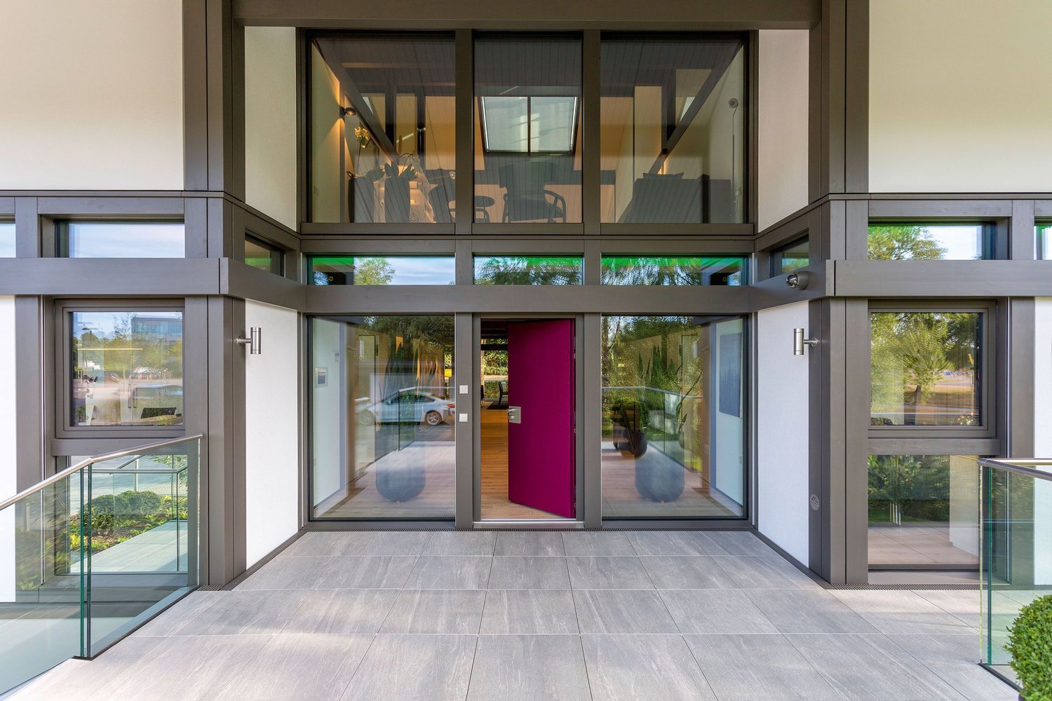 HUF show home London Brooklands 5 Eingangsbereich eines modernen Gebäudes mit Glasfächen und pinker Tür