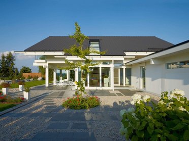 Moderne Architektur mit begrüntem Garten und Terrasse.