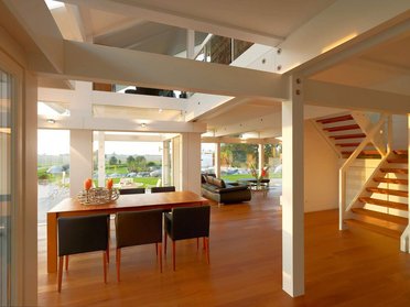 Modernes Innenraumdesign mit Holzfußboden und großen Fenstern