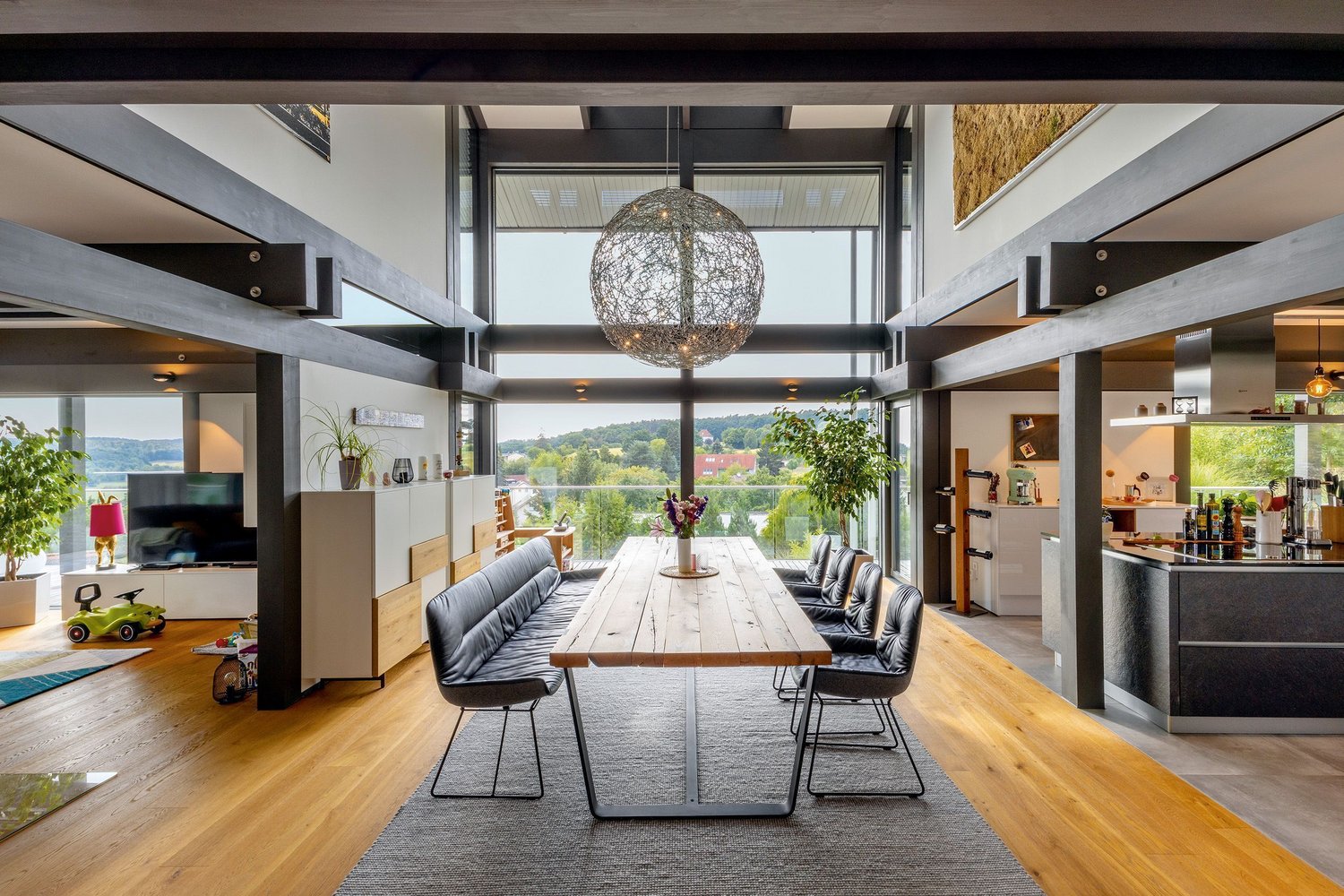 Modernes Architektenhaus mit elegantem Wohnbereich Heller Wohnbereich mit großem Tisch und Blick ins Grüne