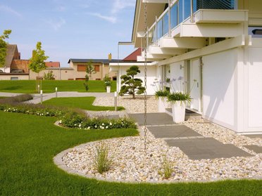Moderne Architektur mit Gartenlandschaft und Pflanzen.