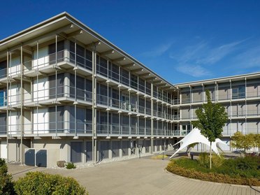 Modernes Bürogebäude HUF bei klarem Himmel Ansicht eines modernen Bürogebäudes mit Pflanzen und klarem Himmel
