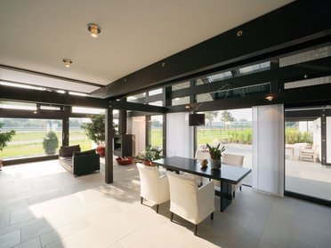 Stylische Einrichtung mit Tisch, Stühlen und Blick ins Freie