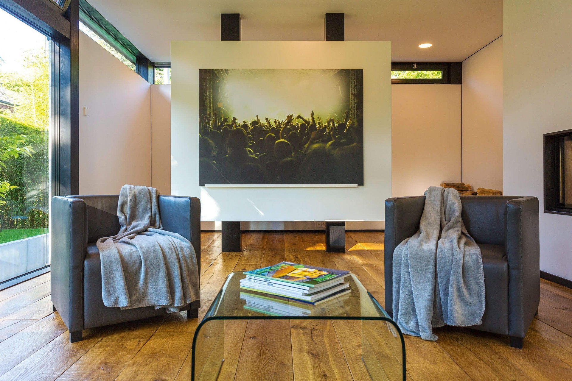 Ein stilvolles Wohnzimmer mit zwei Sesseln, einem Glas-Tisch und einem großen Kunstwerk