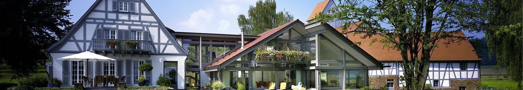 Helles Landhaus mit Gartenlandschaft und spielenden Kindern