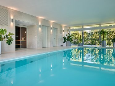 HUF Architektenhaus mit Flachdach und Pool Moderne weiße Villa mit Innenpool und Pflanzen