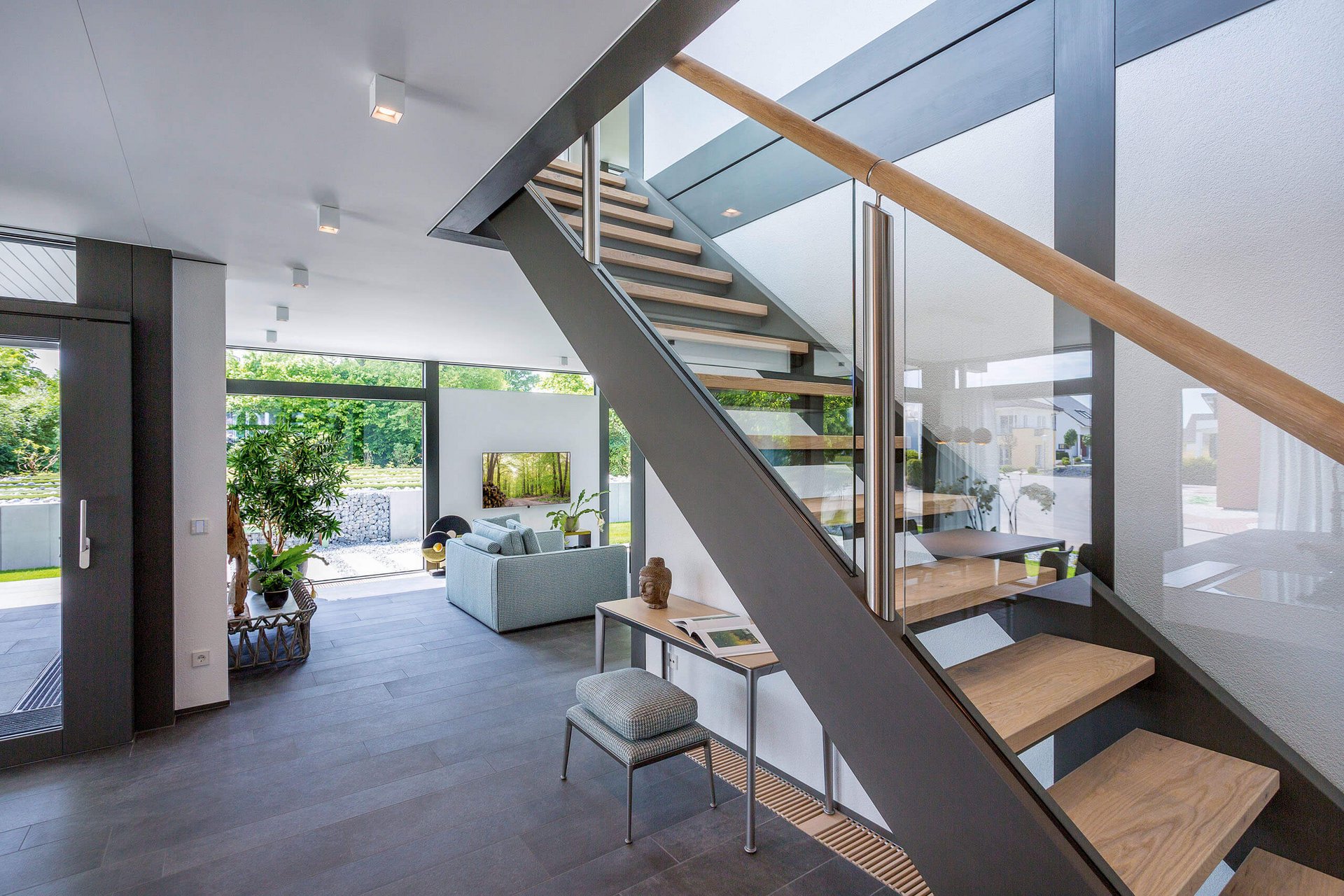 Moderne Treppe in einem stilvollen Wohnraum Lichtdurchfluteter Wohnraum mit Treppe und gemütlicher Sitzecke