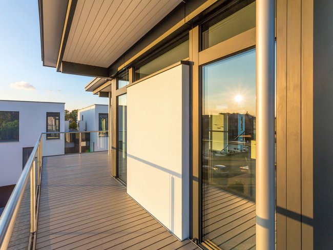 Modernes Bestandshaus mit HUF Aufstockung Ansicht der Terrasse eines zeitgenössischen Hauses mit großen Fenstern