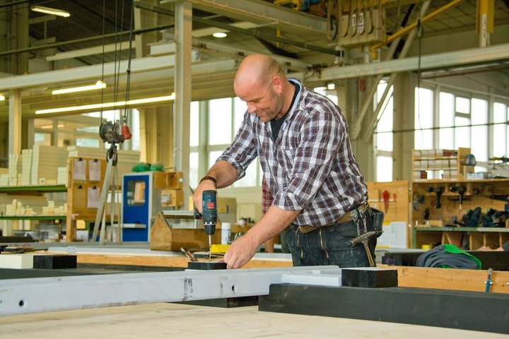 Mann arbeitet in einer Werkstatt mit einer Bohrmaschine