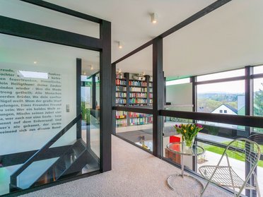 HUF modum Flachdach ebenholz 12 Innenansicht eines modernen Fachwerkhauses mit Flachdach und Bücherregal