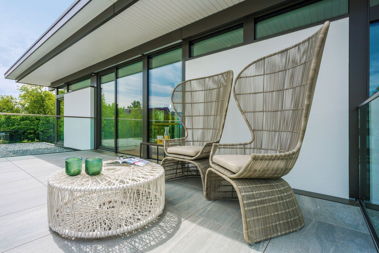 Moderne Terrasse mit stilvollen Möbeln Zwei elegante Stühle und ein runder Tisch auf einer Terrasse