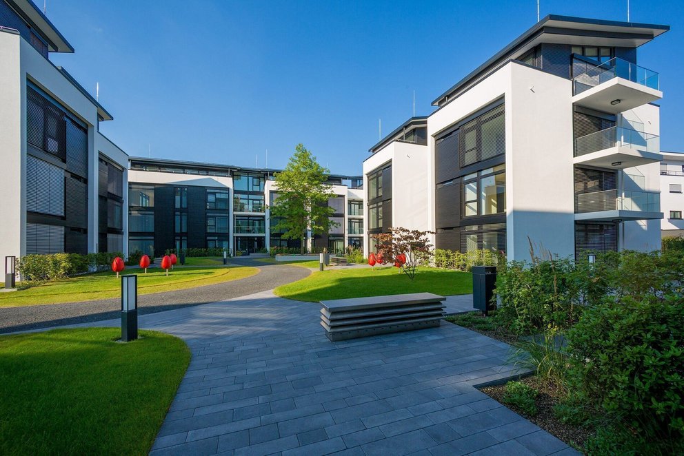 Moderne Wohnanlage mit Grünflächen und Architektur Ansicht einer modernen Wohnanlage mit Garten und Architekturdetails
