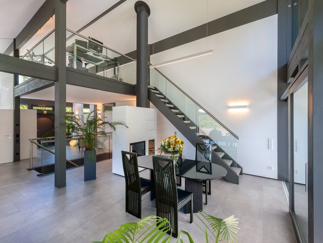 Geräumiger Wohnraum mit Treppe, Esstisch und Pflanzen.