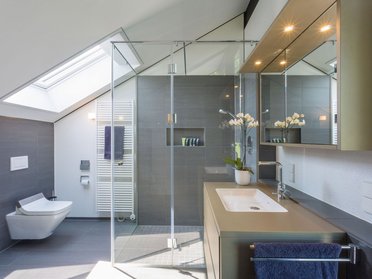 Helles Badezimmer mit Dusche, Badewanne und großen Fenstern