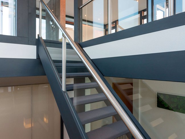 Moderne Treppe in einem Aufgestockten Haus Innensicht mit Treppe und Glasgeländer in einem modernen Bestandsgebäude