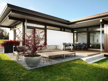Bungalow mit Garten, Holzterrasse und modernen Möbeln