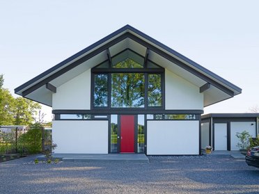 Vorderansicht eines modernen Architektenhauses mit großen Fenstern