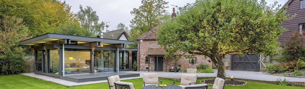 Blick auf ein modernes Haus und ein traditionelles Gebäude im Garten