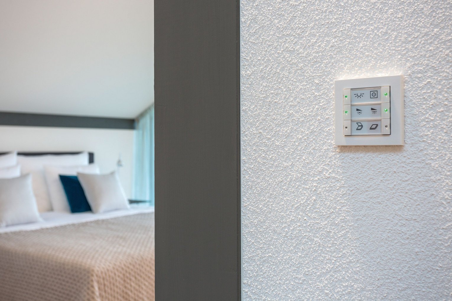 Moderne Lichtsteuerung in Hotelzimmeransicht Lichtschalter im Fokus mit Blick auf ein stilvolles Hotelzimmer