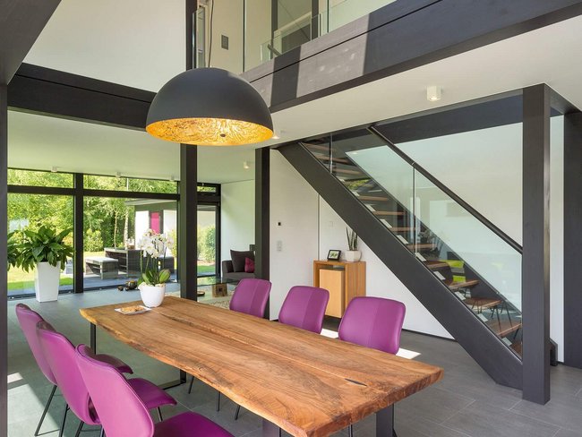Gemütliches Architektenhaus mit modernem Design Stilvolles Interieur mit Holzstehlampe und Esstisch.