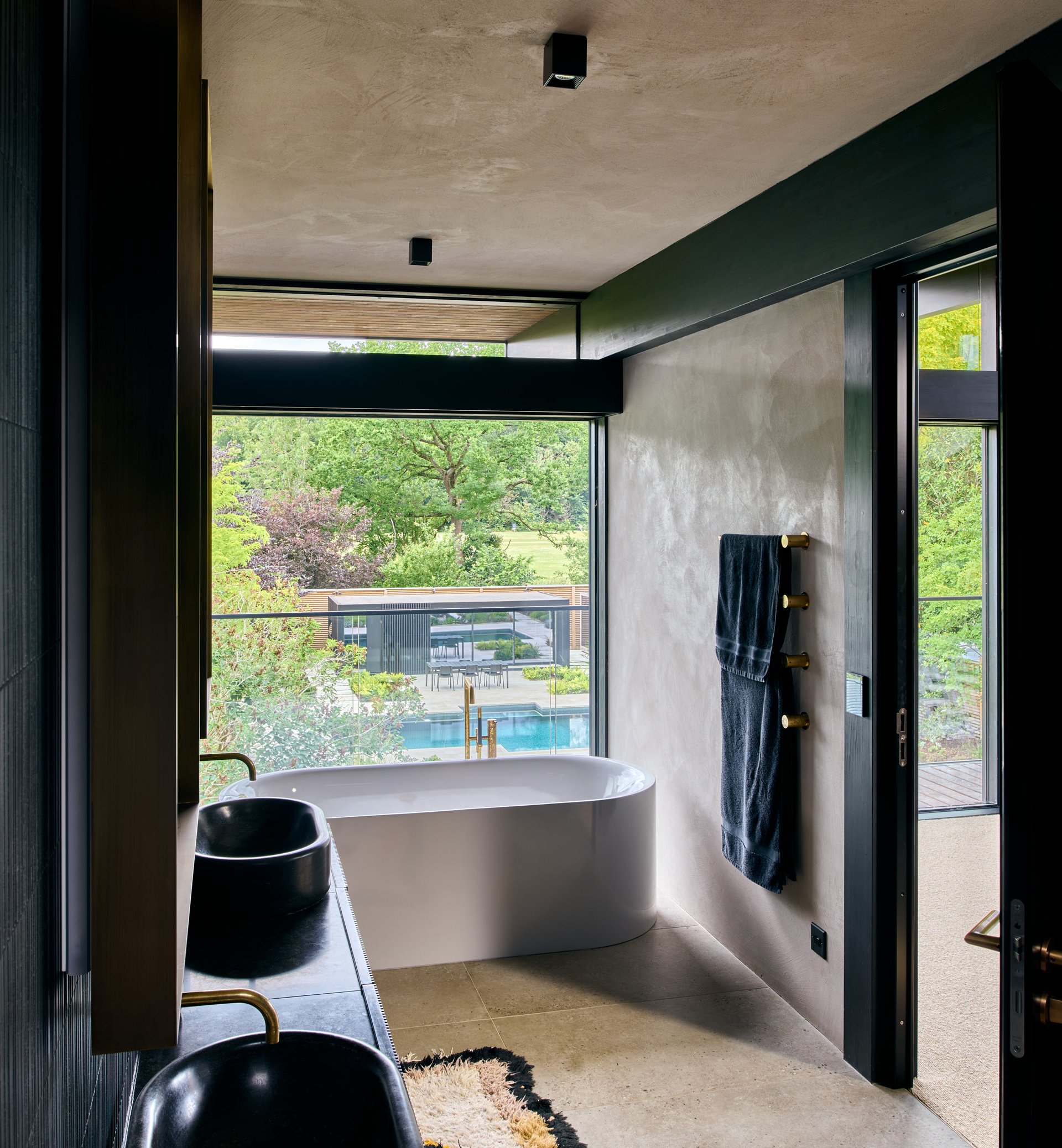 Elegantes Badezimmer mit Badewanne und Fenster zum Garten